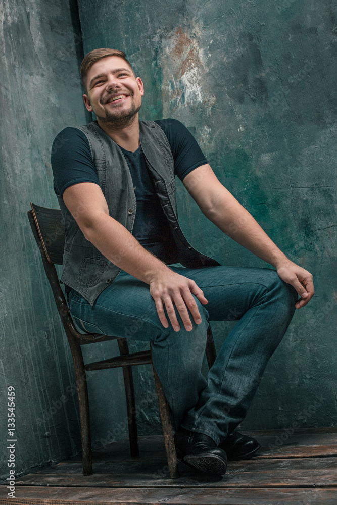 Portrait of smiling happy man sitting on the chair in studio Portrait of smiling happy man sitting on the chair in studio