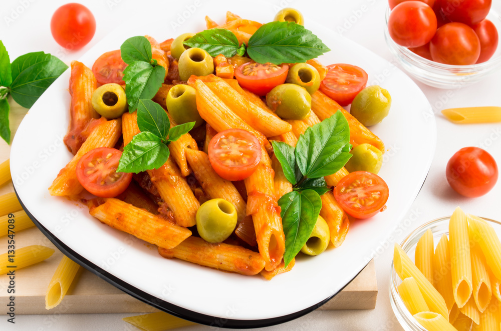 Plate of penne pasta decorated with cherry tomatoes