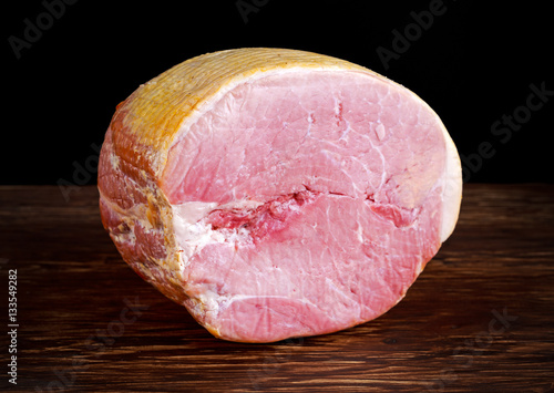 Butcher's deli ham on wooden board background photo