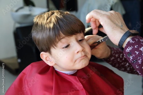 haircut of small boy in barbershop