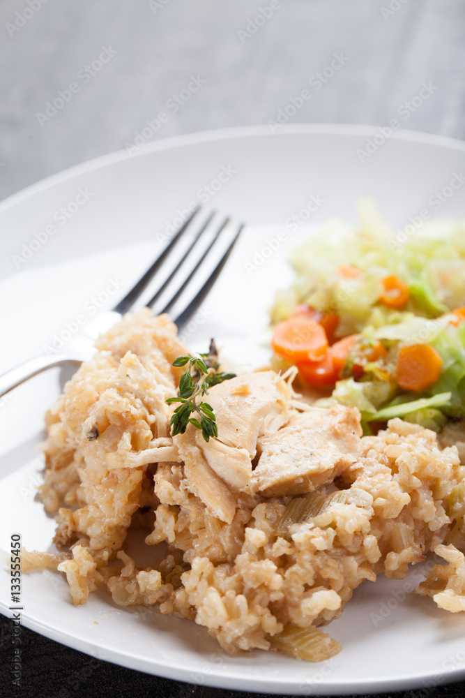 Lemon pepper chicken on brown rice with steamed carrots and cabbage on a dark wooden background vertical shot Lemon pepper chicken on brown rice with steamed carrots and cabbage on a dark wooden background vertical shot