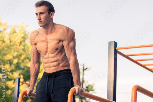 Muscular man during his workout on the street