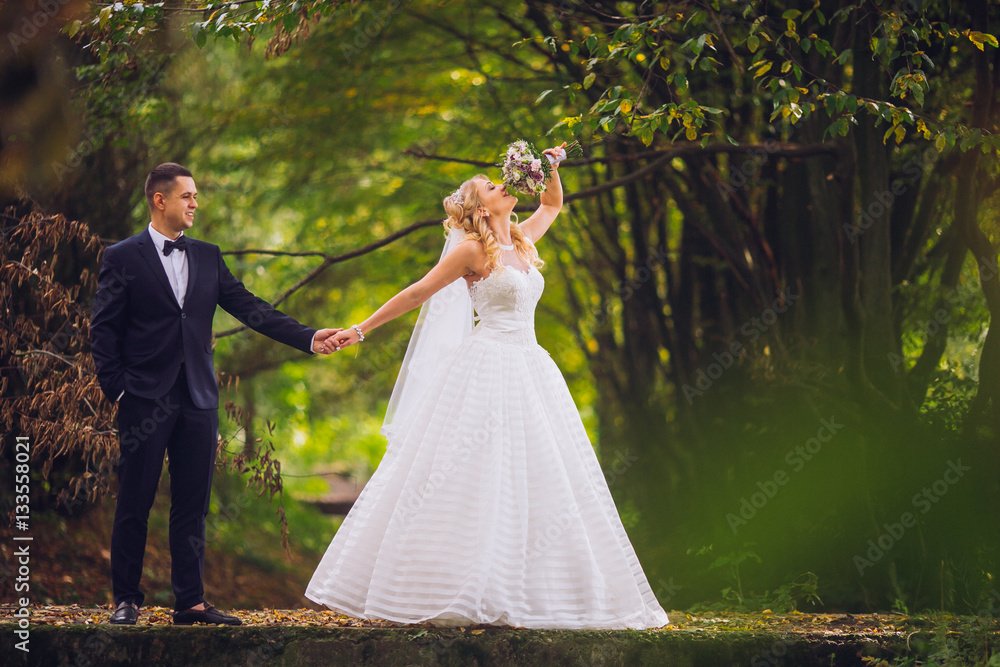 Bride and groom in a park kissing.couple newlyweds bride and groom at a wedding in nature green forest are kissing photo portrait.Wedding Couple