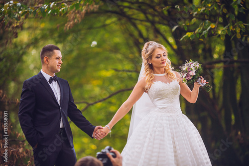 Bride and groom in a park kissing.couple newlyweds bride and groom at a wedding in nature green forest are kissing photo portrait.Wedding Couple
