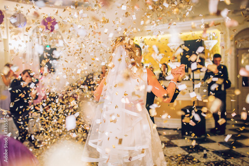 Obraz na płótnie beautiful caucasian couple just married and dancing their first dance confetti around w salonie