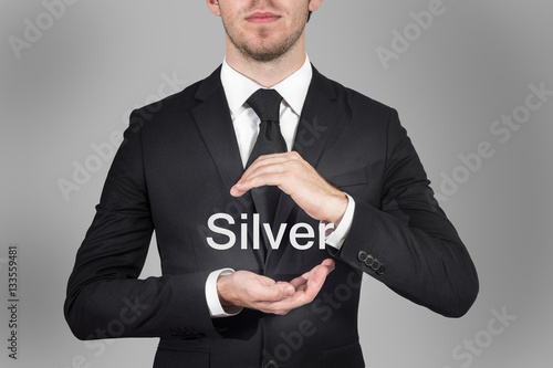 businessman protecting word silver with hands