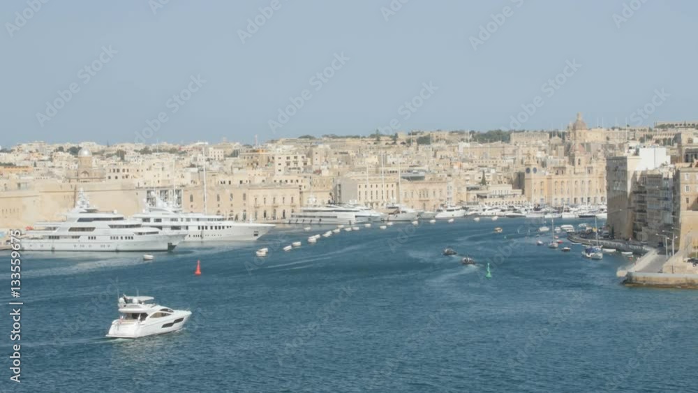Valletta, Malta. Boat floating in capital with beautiful waterfront view. June 2016. Valletta, Malta. Boat floating in capital with beautiful waterfront view. June 2016.