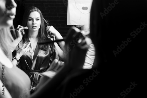 Beautiful plus-size model preparing for a runway show in dress and with make up. Backstage