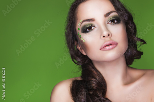 Beautiful brunette woman with creative make up. Close up of a face. Colorful background