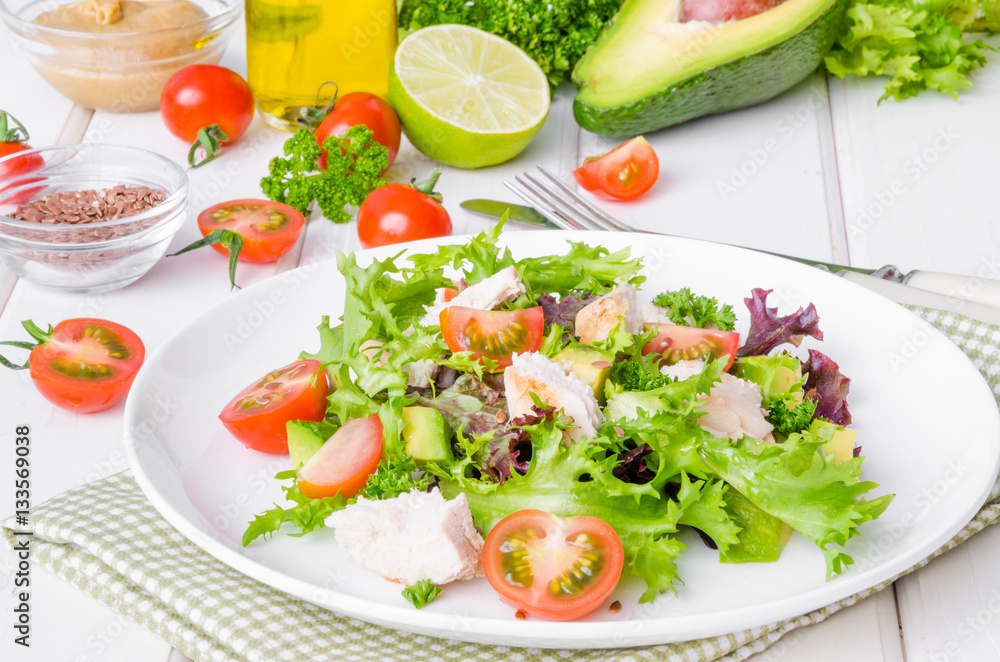 Fresh salad with chicken, avocado, tomatoes and flax seeds on a plate on white wooden background. Healthy food. Fresh salad with chicken, avocado, tomatoes and flax seeds on a plate on white wooden background. Healthy food.