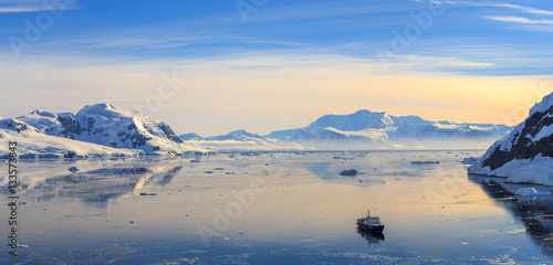 Fototapeta Neco bay surrounded by glaciers and cruise vessel drifting slowl