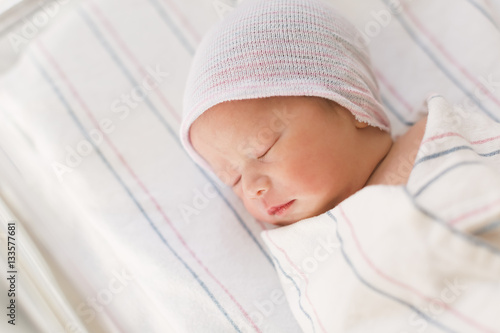 Newborn infant baby boy lying in a hospital bed