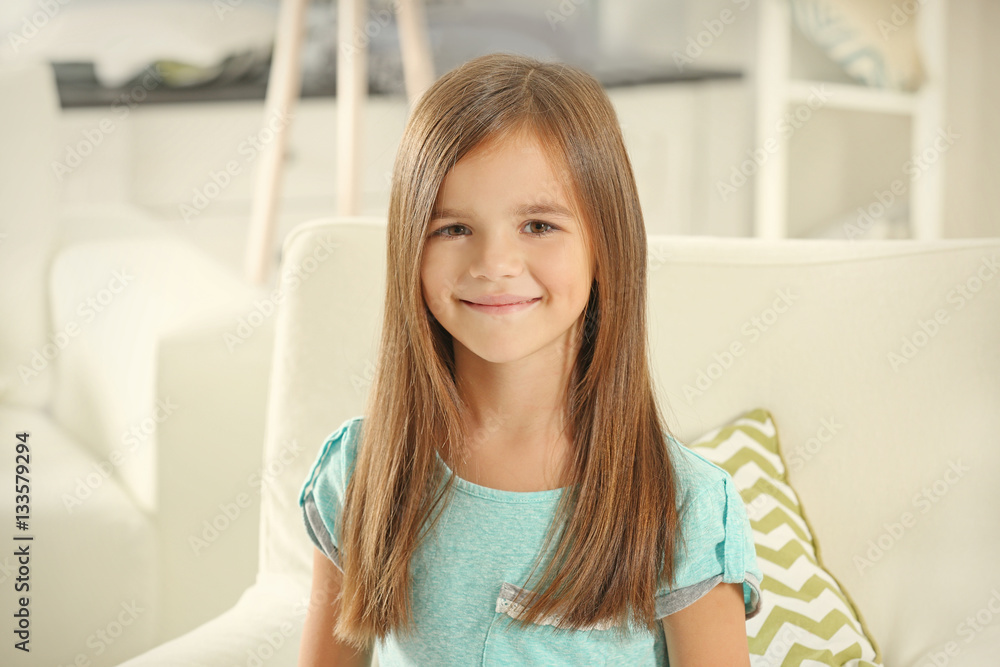 Portrait of cute little girl sitting on armchair at home Portrait of cute little girl sitting on armchair at home