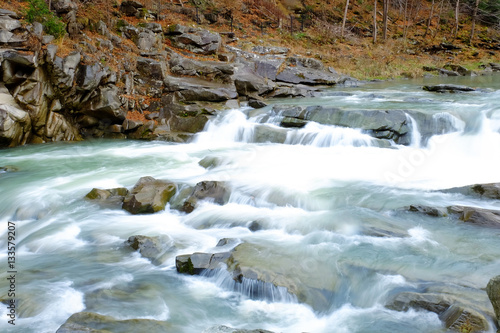 Mountain river flowing through autumn forest