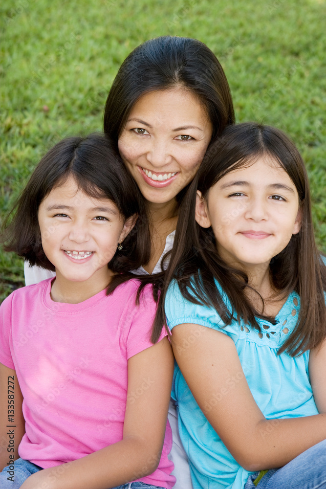 Loving Asain mother and her daughters smiling. Loving Asain mother and her daughters smiling.
