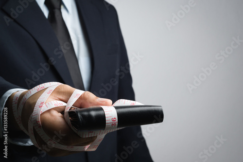 Business man with wallet wrapped by measuring tape
