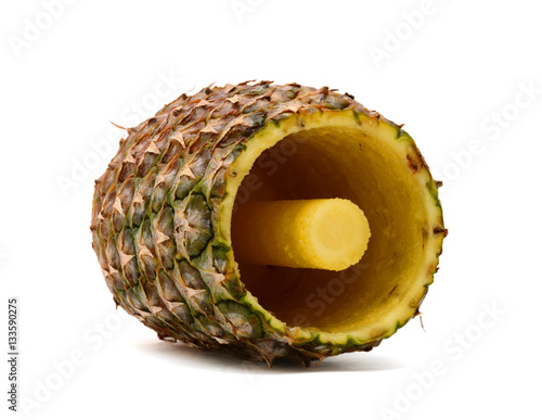 A pineapple has been cored and sliced using a corer and slicer utensil