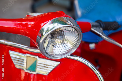 headlight of old red motorcycle, close up