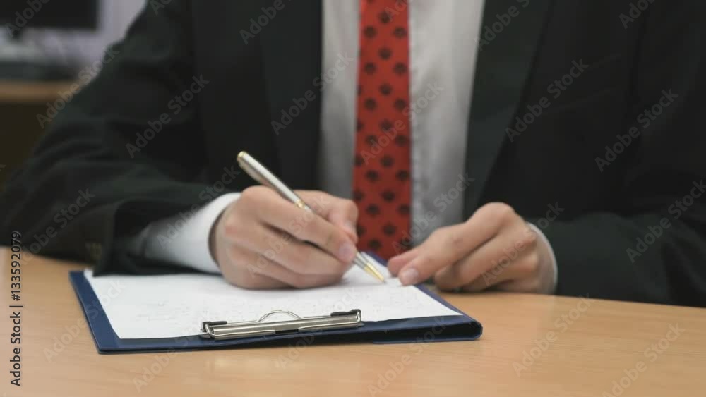 Teenager sitting at the desk writing the text using a ballpoint pen indoors Teenager sitting at the desk writing the text using a ballpoint pen indoors