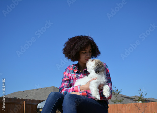Shih Tzu Kiss/MIxed race teenage girl hold and kissing a Shih Tzu dog.