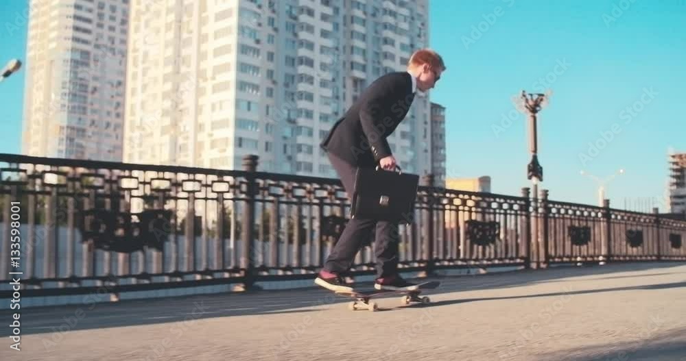 Businessman performing jump on skateboard while riding in city at summer day Businessman performing jump on skateboard while riding in city at summer day