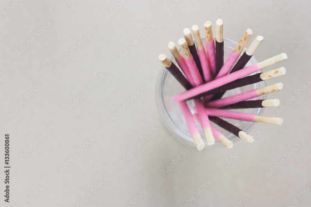 Chocolate and pink biscuits sticks in glass Chocolate and pink biscuits sticks in glass