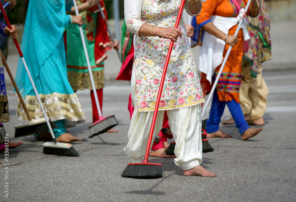 many barefoot women sweep the road during the ceremony along the