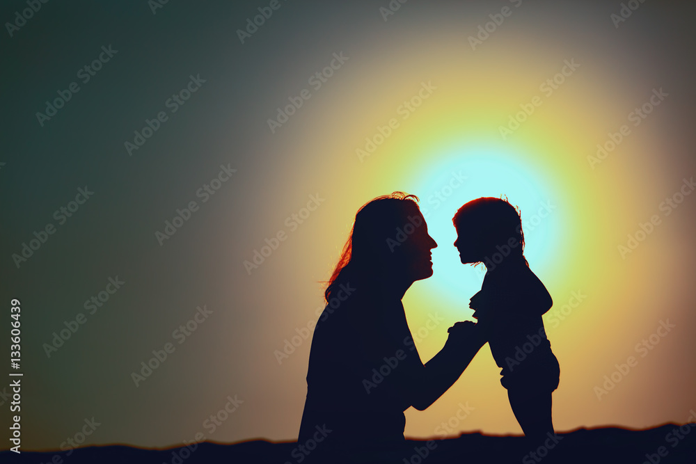 happy mother and little daughter at sunset happy mother and little daughter at sunset