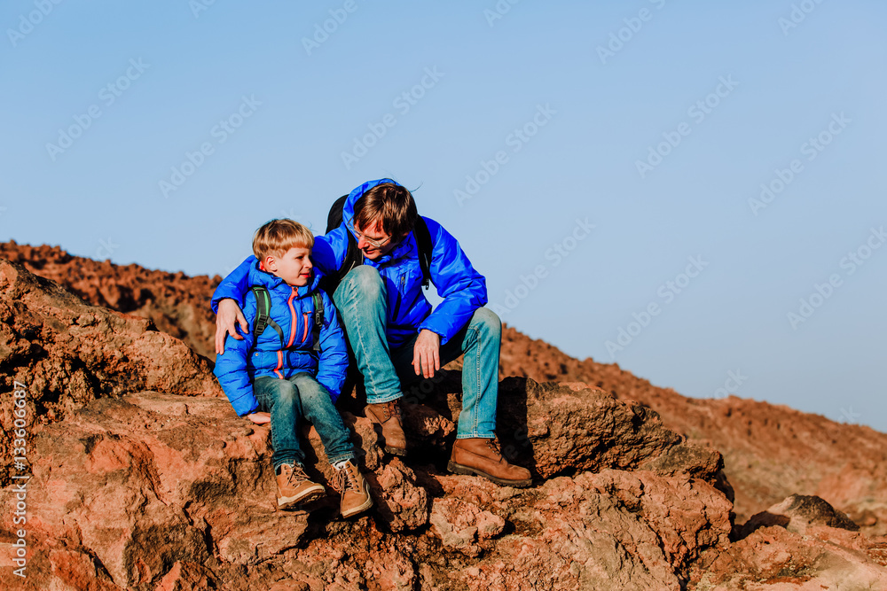 father and son hiking climbing in mountains