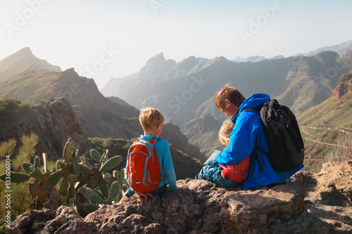 father and two kids hiking climbing in mountains