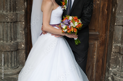 Beautiful bride and groom with bouquet before wedding ceremony