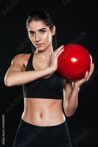 Concentrated sports woman holding fitness ball and looking at camera © Drobot Dean