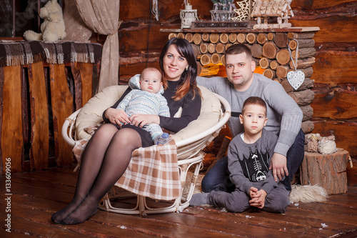 Young family with two children near fireplace celebrating Christ