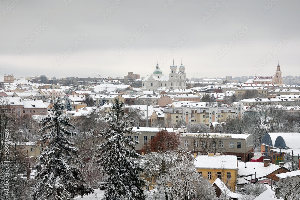 Panorama Grodno after a snowfall. Roofs of old houses and a Catholic churches covered with snow in perspective. Belarus winter.
