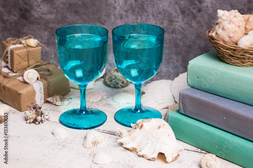 Blue glasses, shells, books, gifts on wooden vintage white background