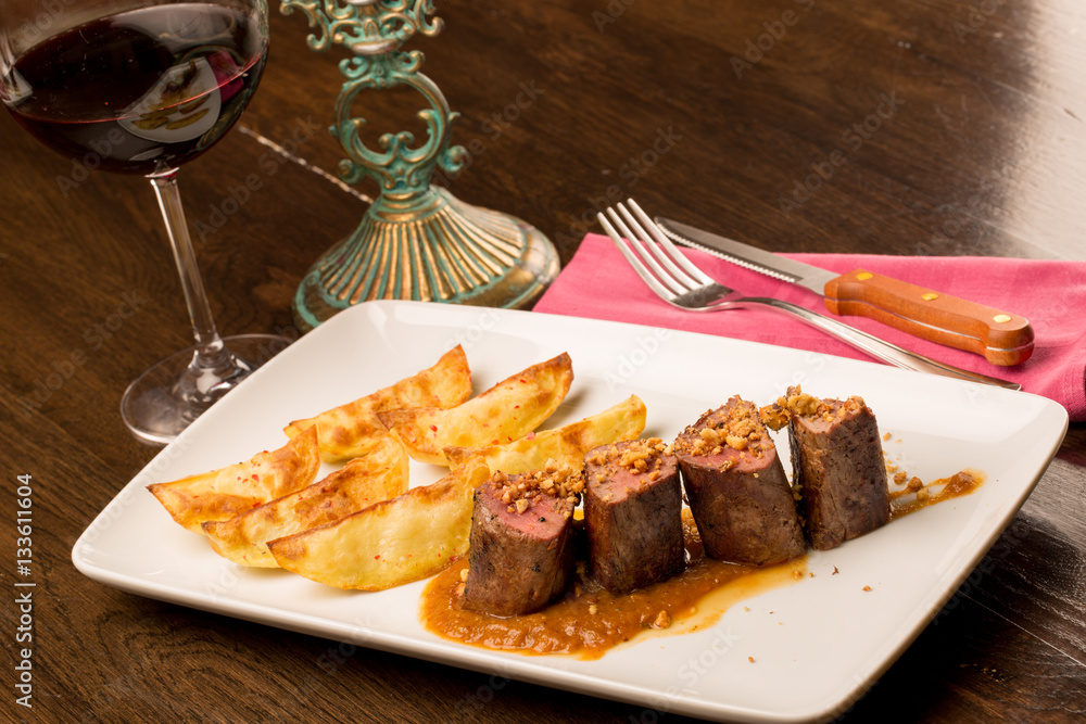 Close up of forest animal steak with potatoes and a glass of win Close up of forest animal steak with potatoes and a glass of win
