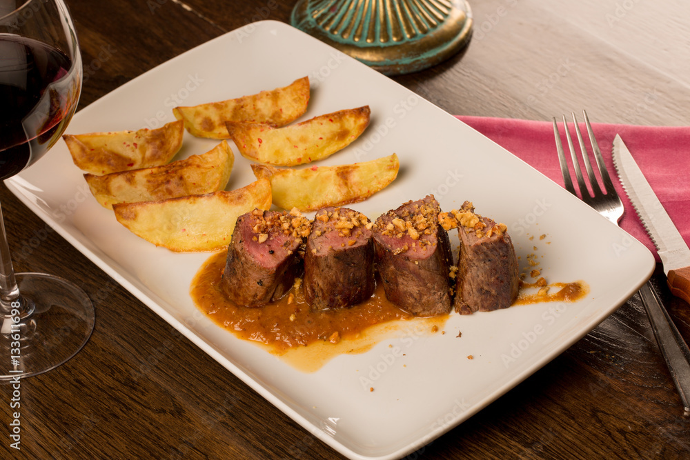 Close up of forest animal steak with potatoes and a glass of win Close up of forest animal steak with potatoes and a glass of win