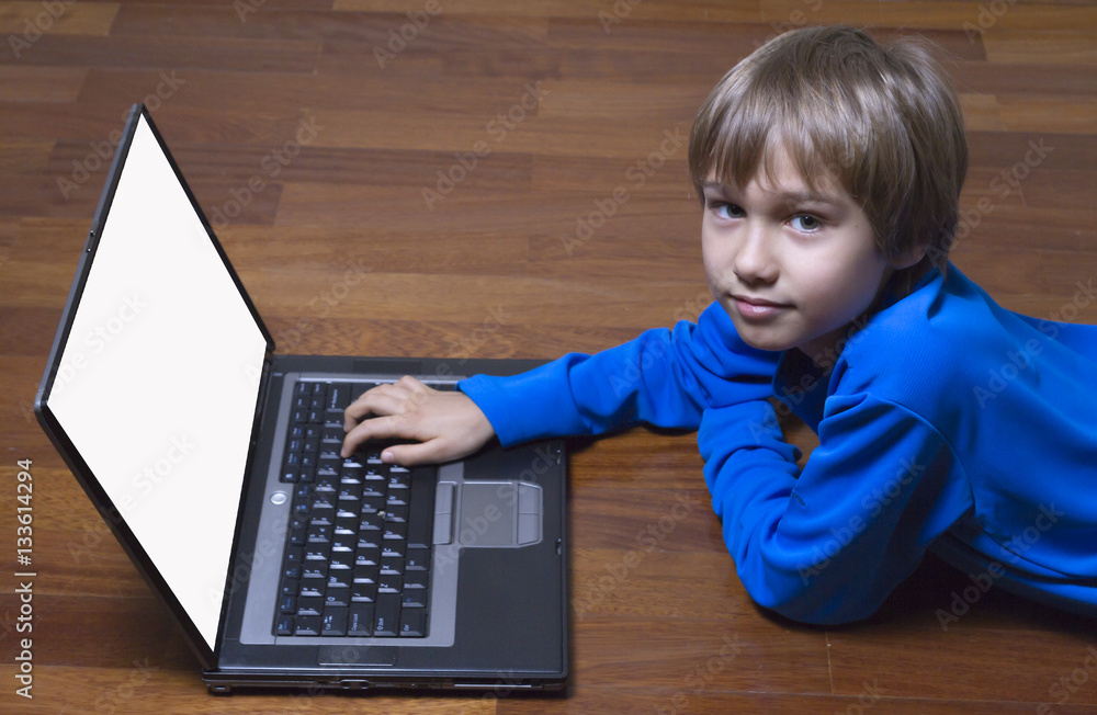 Child using laptop PC lying on wooden floor. Top view. Education ...