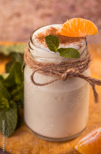 Fresh organig natural white yogurt in glass jars with tangerine photo