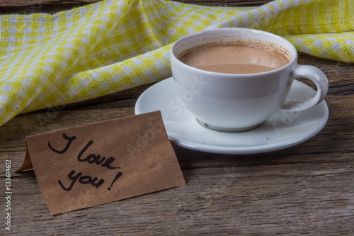 Note I love you with cup of coffee on wooden background