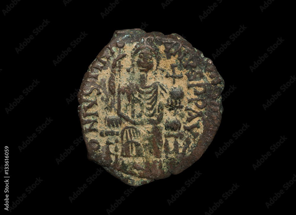 Ancient copper Byzantine copper coin with figure on it isolated on black Ancient copper Byzantine copper coin with figure on it isolated on black