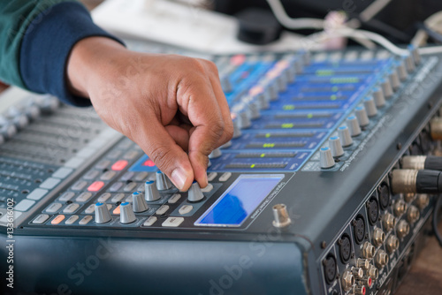 Hand adjusting audio mixer