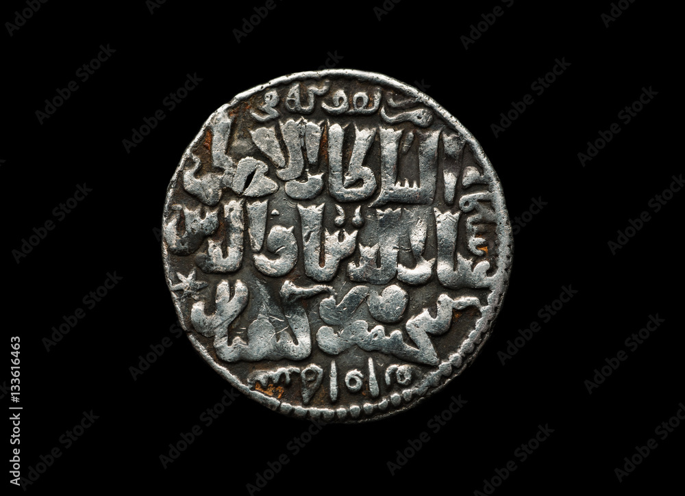 Ancient Seljuk silver coin with text on it isolated on black