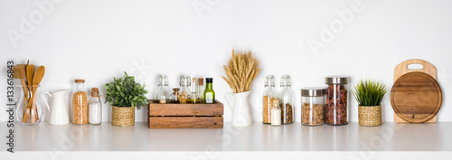 Kitchen shelf with various herbs, spices, utensils on white background