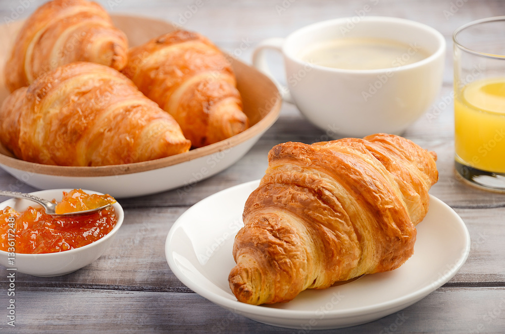 Fresh Croissants with coffee, jam and orange juice for breakfast on rustic wooden background, selective focus Fresh Croissants with coffee, jam and orange juice for breakfast on rustic wooden background, selective focus