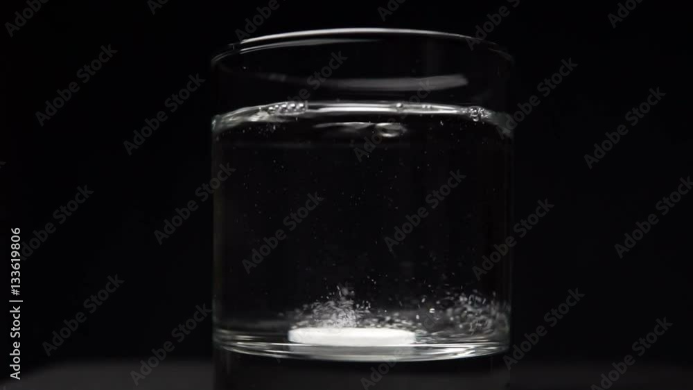 Effervescent Antacid Tablet in Glass of Water on Black Effervescent Antacid Tablet in Glass of Water on Black