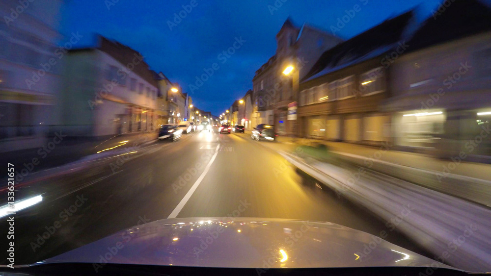 car drives at night in the city with motion blurred background