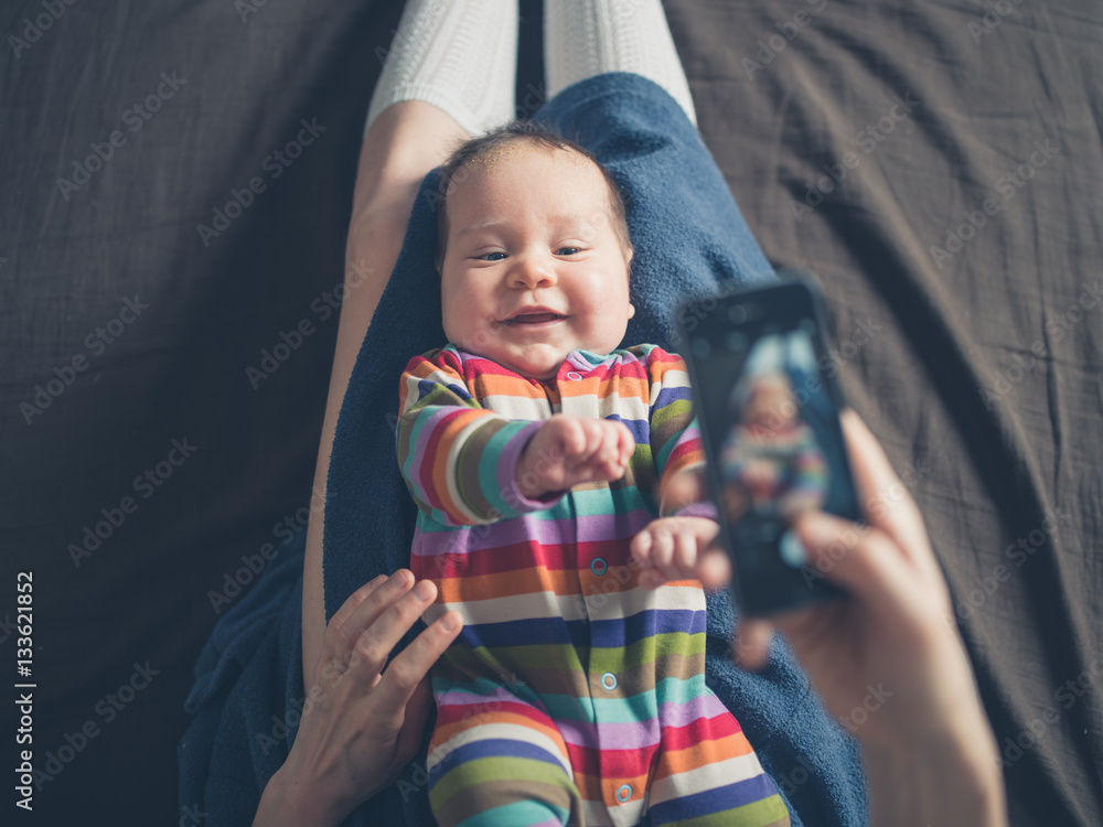 Obraz premium Mother taking photo of her baby
