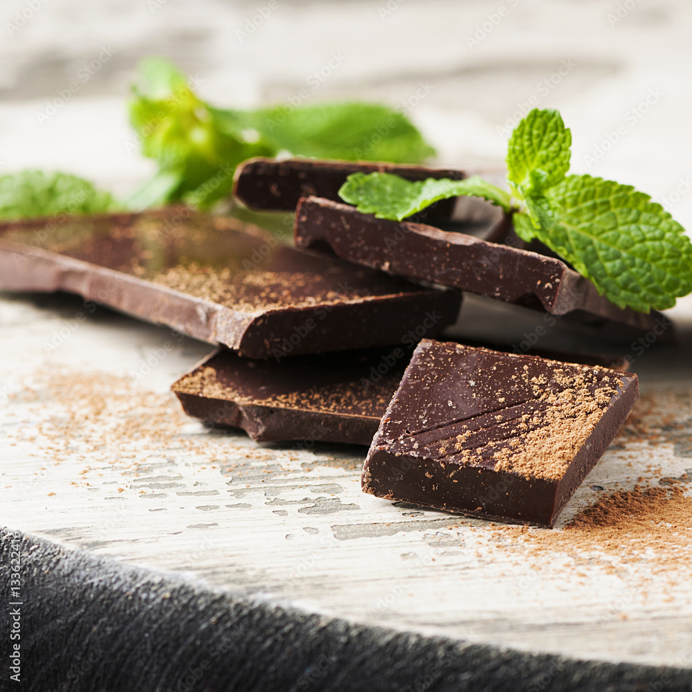 Brown chocolate and mint on the wooden table Brown chocolate and mint on the wooden table