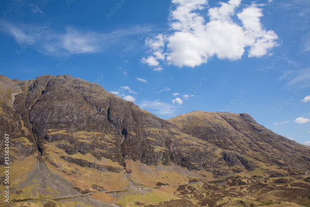 White clouds over Scottish mountains in spring with sunshine Glencoe Scotland UK famous tourist destination White clouds over Scottish mountains in spring with sunshine Glencoe Scotland UK famous tourist destination